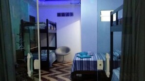 A small, compact room with bunk beds, a chair, and a patterned floor. - Pousada Recanto Dom Lázaro (Cesario Lange)