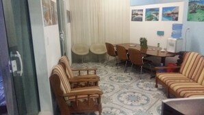 A dining area with a table, chairs, and a sofa. - Pousada Recanto Dom Lázaro (Cesario Lange)