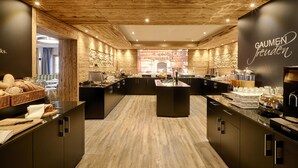 Uma cozinha moderna com teto de madeira, bancadas pretas e uma ilha central com cafeteira.