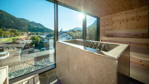 Decoração moderna com uma grande janela que oferece uma vista panorâmica de um vale e montanhas.