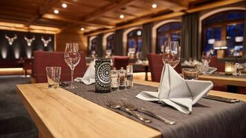 A restaurant setting with wooden tables, red upholstered chairs, and a patterned centerpiece.
