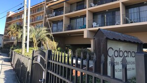 A multi-story hotel with balconies, a gated entrance, and a sign indicating "Cabana Private Residences." - Stunning ocean front condo with an extraordinary view of the Fabulous Boardwalk! (Carolina Beach)