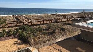 A beach view with wooden walkways and a pool area. - Stunning ocean front condo with an extraordinary view of the Fabulous Boardwalk! (Carolina Beach)