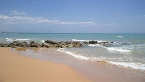 A beach with clear skies, calm water, and rocky outcrops. - House / Villa - Marina di Ragusa, Ragusa (Marina di Ragusa)