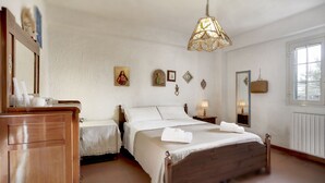 A bedroom with a wooden bed, a nightstand, a dresser, a mirror, and a hanging light fixture. - House / Villa - Marina di Ragusa, Ragusa (Marina di Ragusa)