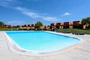 A rectangular swimming pool with a clear blue water surface, surrounded by a paved deck. - L'Orangerie (Vilamoura)