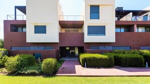 A modern multi-story building with a flat roof, large windows, and a central entrance.