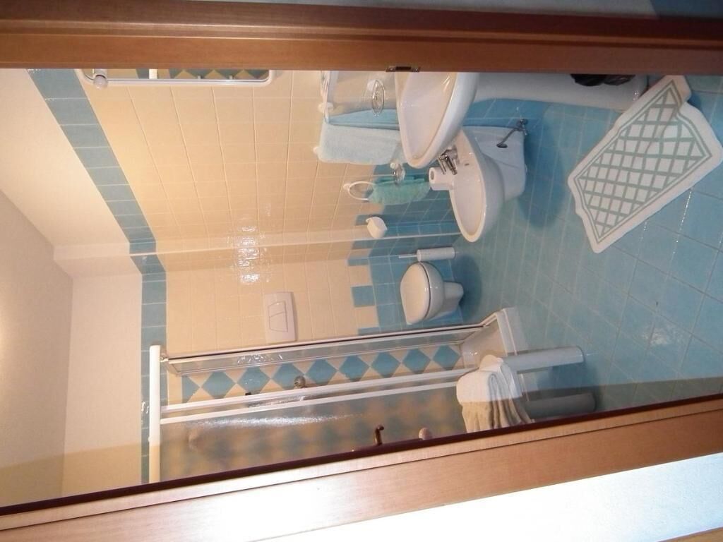 A bathroom with a toilet, sink, and shower area.