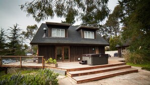 Une maison à deux étages dotée d’une terrasse, d’un jacuzzi et d’un espace salon extérieur abrité.