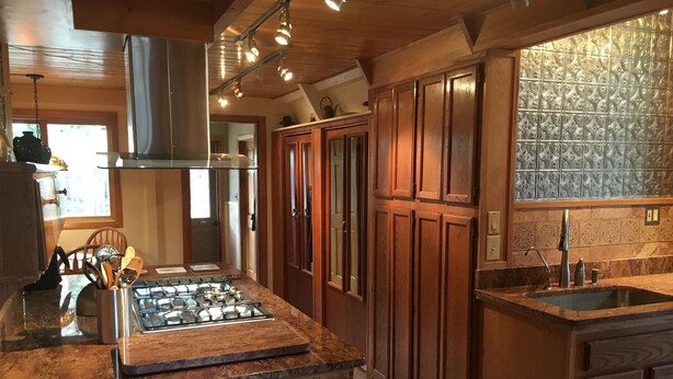 Una cucina moderna con mobili in legno, un fornello a gas e una grande isola.