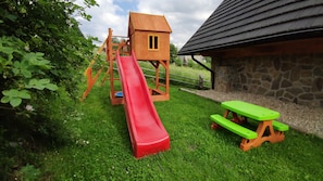 A playground with a slide, a climbing structure, and a picnic table. - Tatrzański Ogród (Zakopane)