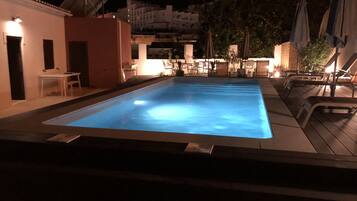 Een buitenzwembad, parasols voor strand/zwembad