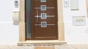 Ein Gebäude mit einer braunen Tür, Hausnummer 11, und einem kleinen Fenster darüber.