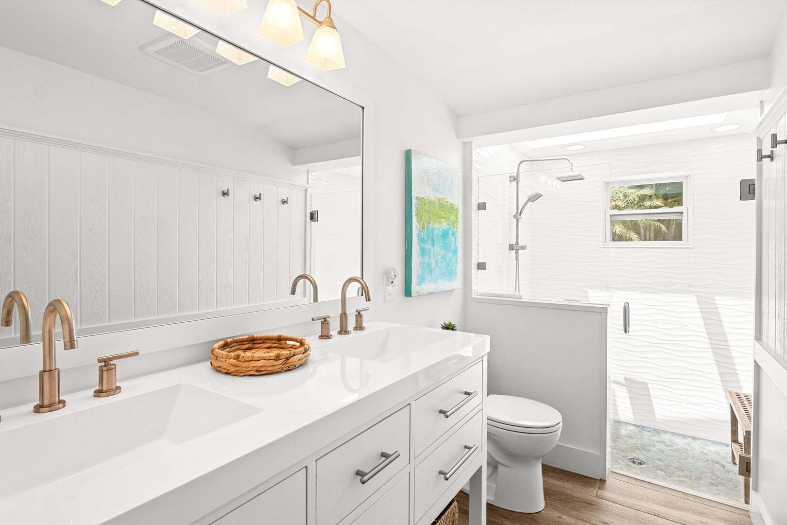A modern bathroom with a large mirror, two sinks, a toilet, and a shower.