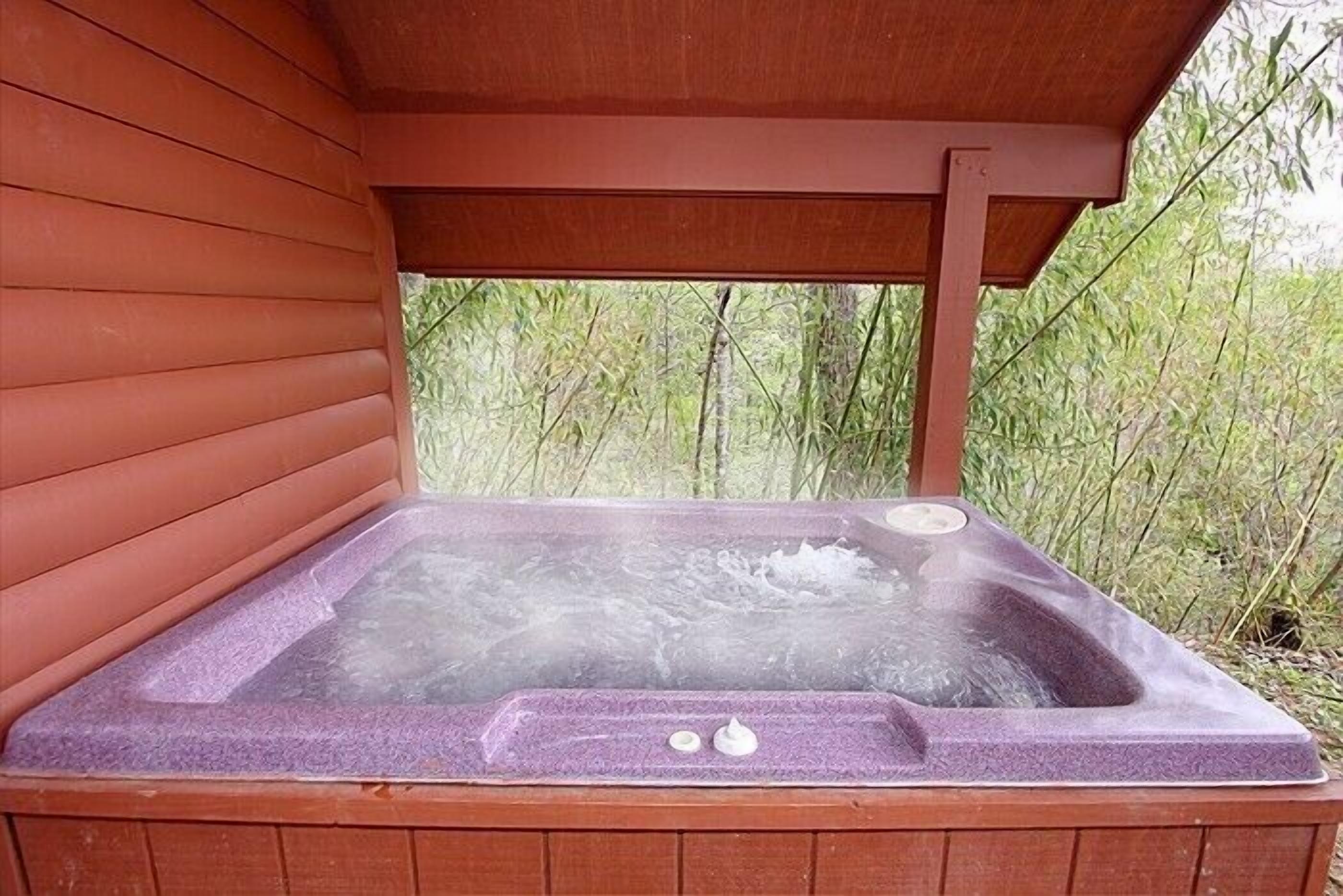 Un jacuzzi con estructura de madera y vistas a zonas verdes.