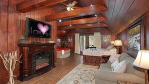 Un salon confortable avec une cheminée, un téléviseur et un canapé.