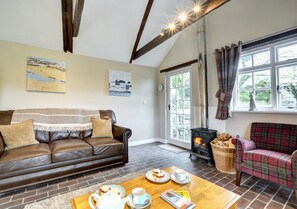 Relax in this inviting living room with a dark leather sofa, plaid sofa, and wooden coffee table.