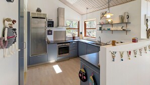 A modern kitchen with a stainless steel refrigerator, built-in oven, and a large window. - Cozy home in ålbæk with WiFi (Ålbæk)