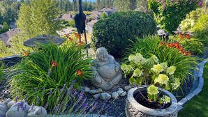 A garden with various sculptures and plants, including a large bird sculpture and a Buddha statue. - Perfect couple retreat paradise found at Casa De Luce (Kelowna)
