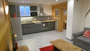 Eine moderne Küche mit grauen Schränken, einer Holz Arbeitsplatte und einem roten Teppich.