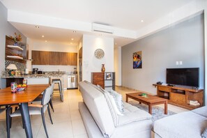 A modern living room with a sofa, coffee table, and TV stand.