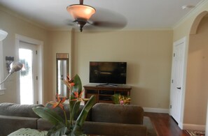 Relax in this inviting living room with a comfortable sofa, flat-screen TV, and ceiling fan.