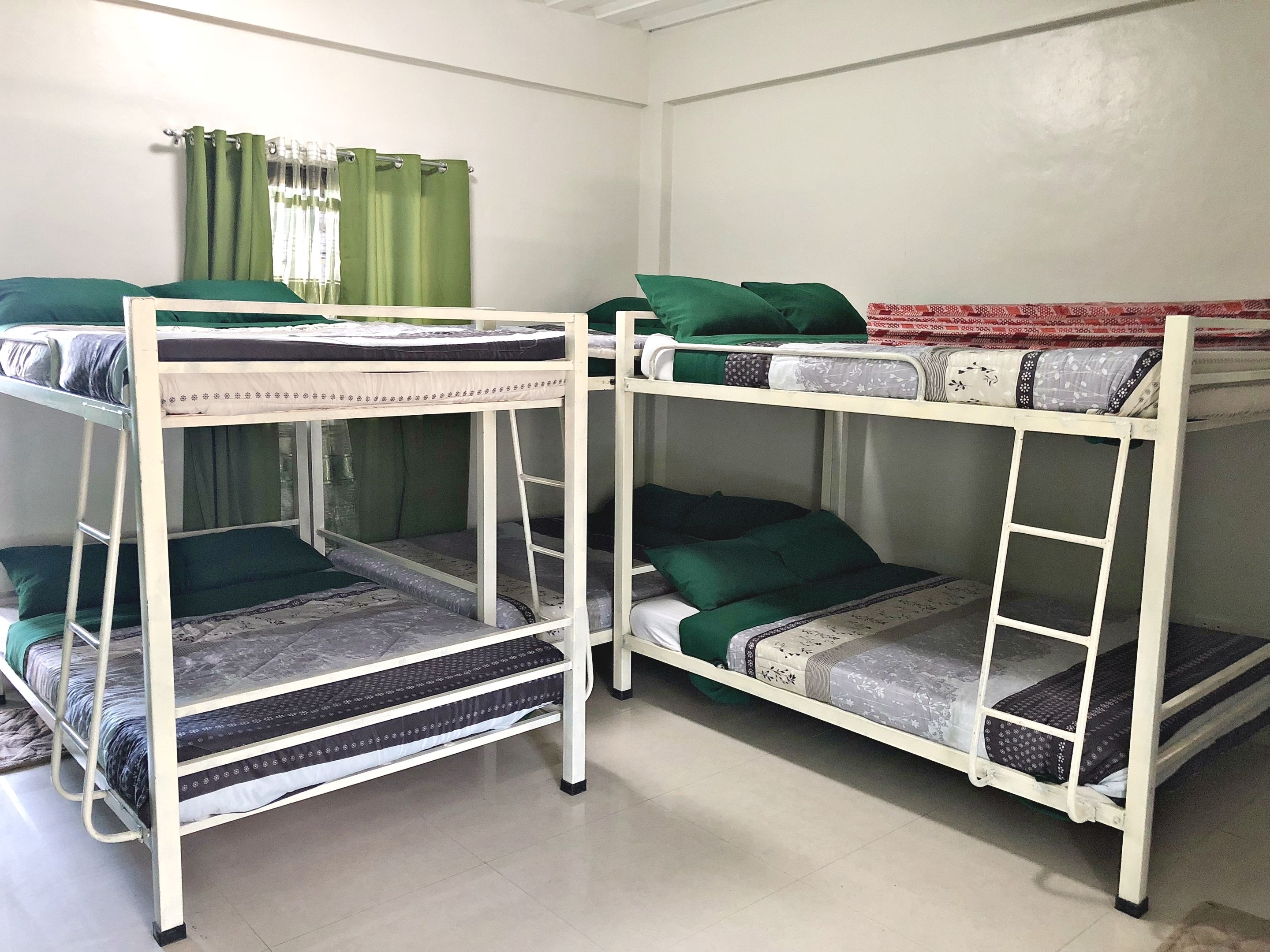 Una habitación con literas, una escalera y una cortina.