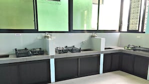 A kitchen with a counter, kettle, and various appliances.