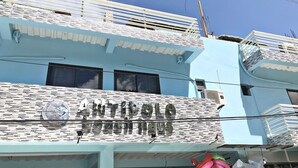 A building with a sign reading "ANTIPOLLO JARDIN ESTACIONADO".