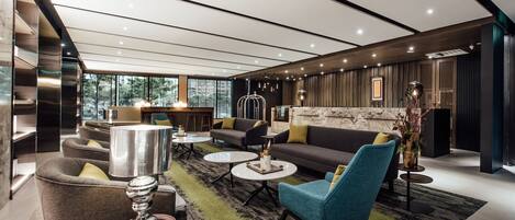 A modern lounge area with sofas, armchairs, and coffee tables.