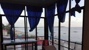 A room with a view of the sea, a wooden bench, and a table. - Antipolo Beach Haus Annex (San Juan)