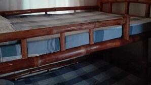 A bunk bed with a wooden frame and blue bedding. - Antipolo Beach Haus Annex (San Juan)