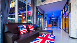 Un moderno vestíbulo de hotel con un sofá de cuero y una mesa con la bandera Union Jack.