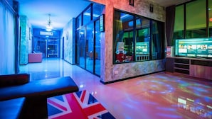 Un moderno hall de hotel con una pared de mármol, un ventanal grande y una zona de estar con un diseño de la bandera del Reino Unido en el suelo.