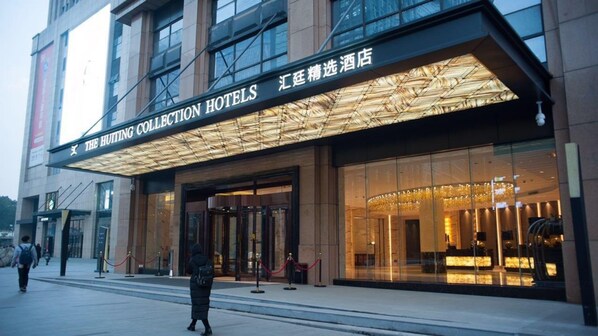 The Huitting Collection Hotels with a modern facade, large glass windows, and a prominent entrance. - The Huiting Collection (Wuhan)