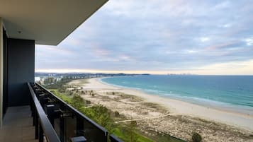 A balcony with a view of a beach and ocean.
