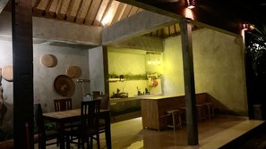 Une cuisine avec un coin bar, des chaises en bois et une table à manger.