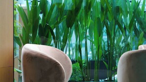 A balcony with a view of a cityscape, featuring a seating area with chairs and a potted plant arrangement. - Cicilia Saigon Center (Ho Chi Minh City)