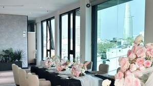 A conference room with a long table set for a meeting, large windows with a city view, and potted plants. - Cicilia Saigon Center (Ho Chi Minh City)