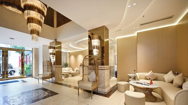 A modern lobby with a reception desk, seating area, and decorative chandeliers. - Cicilia Saigon Center (Ho Chi Minh City)