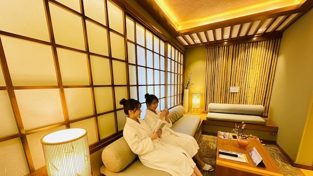 Una habitación tradicional japonesa con suelo de tatami, una mesa de madera baja y un sofá.