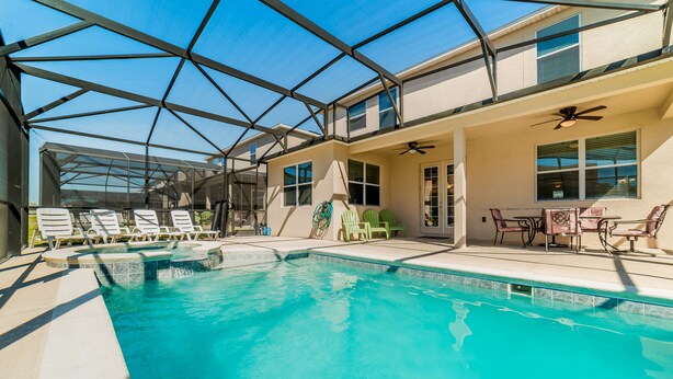 A swimming pool with a glass ceiling, lounge chairs, and a patio area with outdoor furniture. - Shv1189ha - 7 Bedroom Villa In Crystal Cove, Sleeps Up To 16, Just 6 Miles To Disney (Kissimmee)