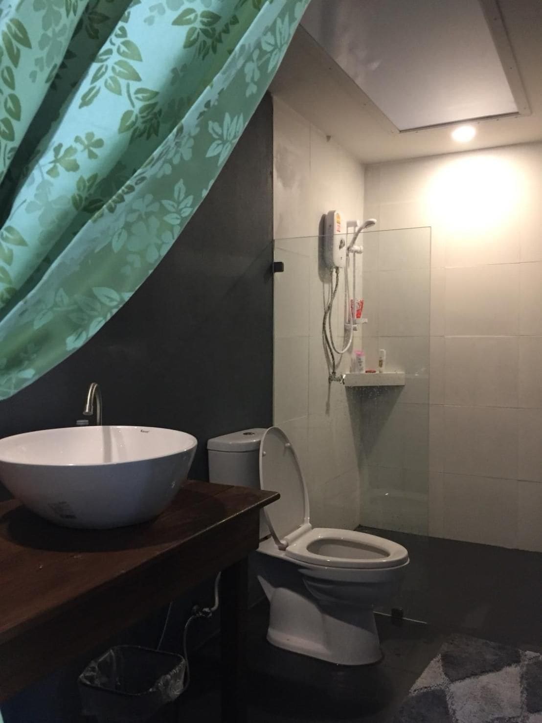 A bathroom with a white sink, toilet, and shower.