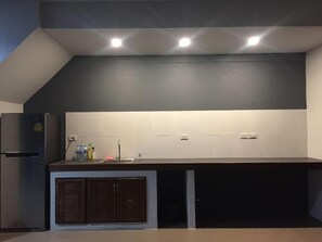 A modern kitchen with a built-in refrigerator, a countertop with a sink, and cabinets. - Anattaya Holiday Home (Ko Yao)