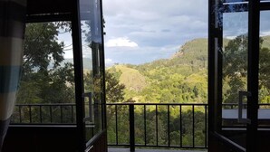 Un balcón con vistas a un valle verde exuberante y colinas.