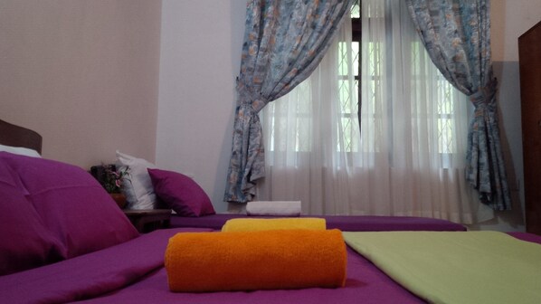 A bedroom with a bed, purple and yellow towels, and a window with curtains. - La Cima Kandy (Kandy)