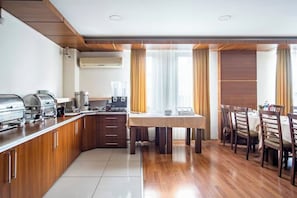 Une cuisine moderne avec un coin repas, des meubles en bois et un système de climatisation intégré.