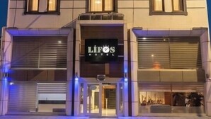 Un hotel de varios pisos con fachada moderna, ventanas iluminadas y una entrada destacada con un letrero que dice 'LIFOS MOTEL'.