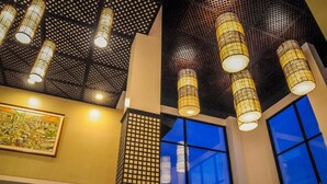 A modern interior with hanging lamps, large windows, and a cityscape painting.