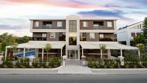A modern hotel with a central entrance, two-story structure, and covered outdoor seating areas. - Atrium Apart Hotel (Cesme)